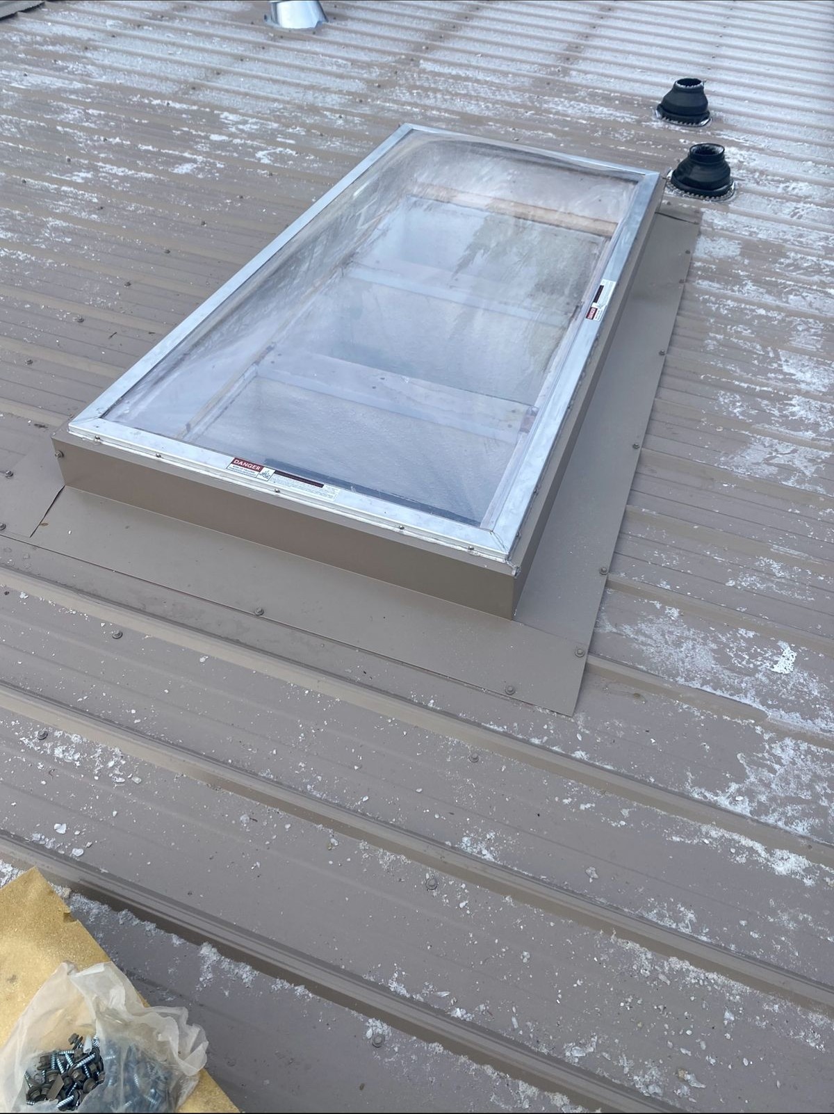 Completed metal roof on a rural Alberta property with clean ridge cap and trim