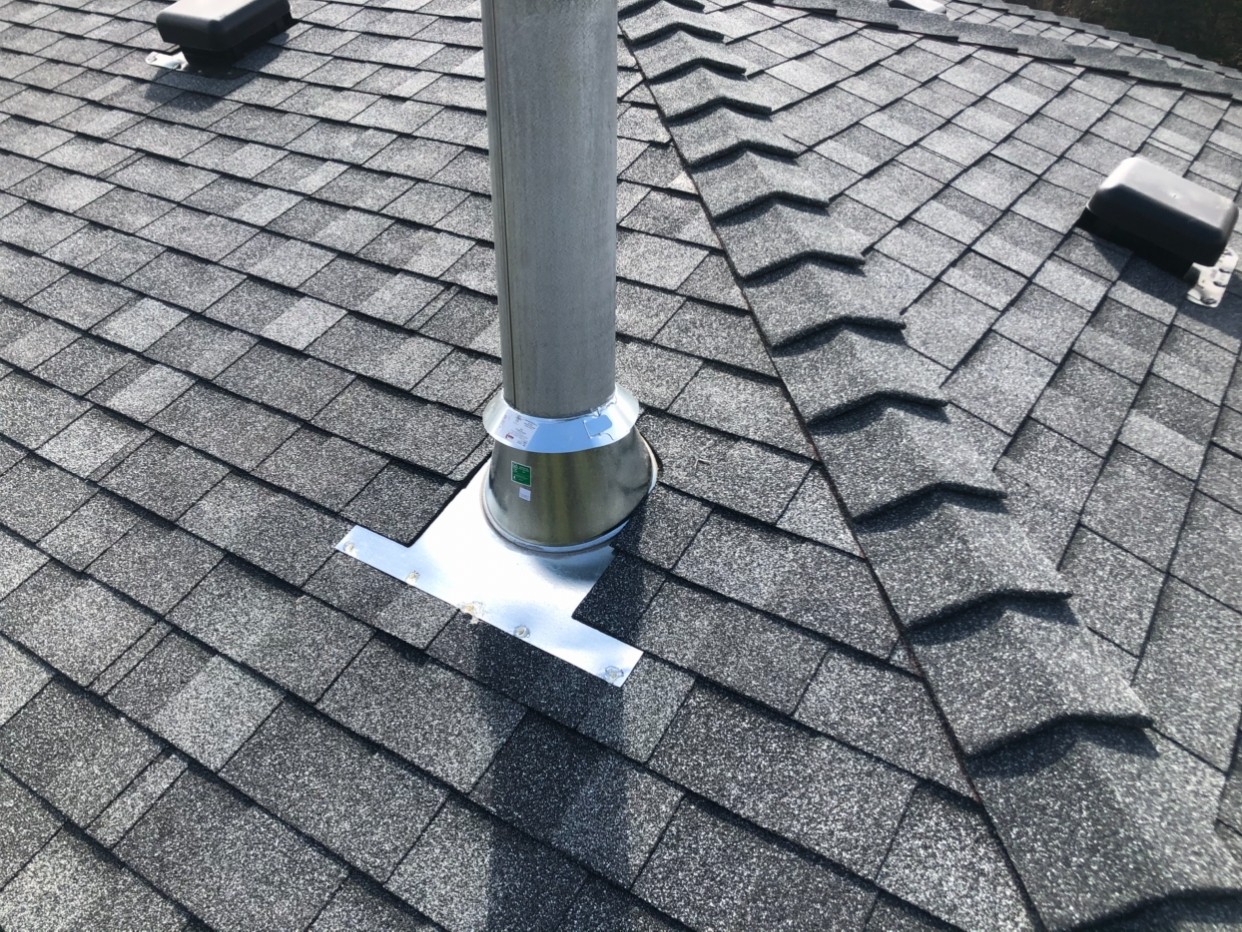 Close-up of architectural shingle installation showing pipe boot flashing in Stony Plain